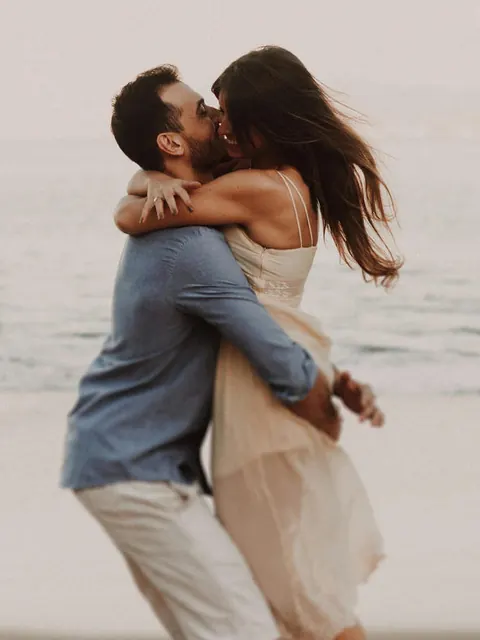 Um casal se abraçando na beira da praia